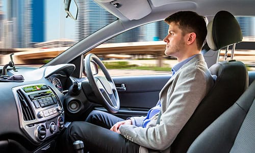 Side View Of A Young Man Sitting Inside Autonomous Car